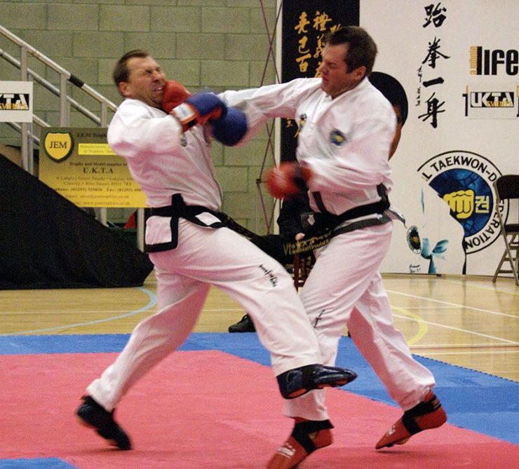 Surrey Taekwon-Do men in sparring competition with one man punching the other with sparring gloves on