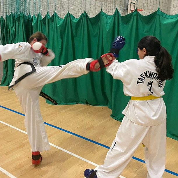 Surrey Taekwon-Do lady performing a kick with another lady blocking the kick