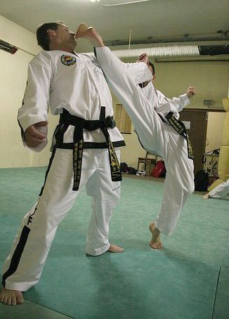 Surrey Taekwon-Do student performing a high kick with instructor avoiding the contact